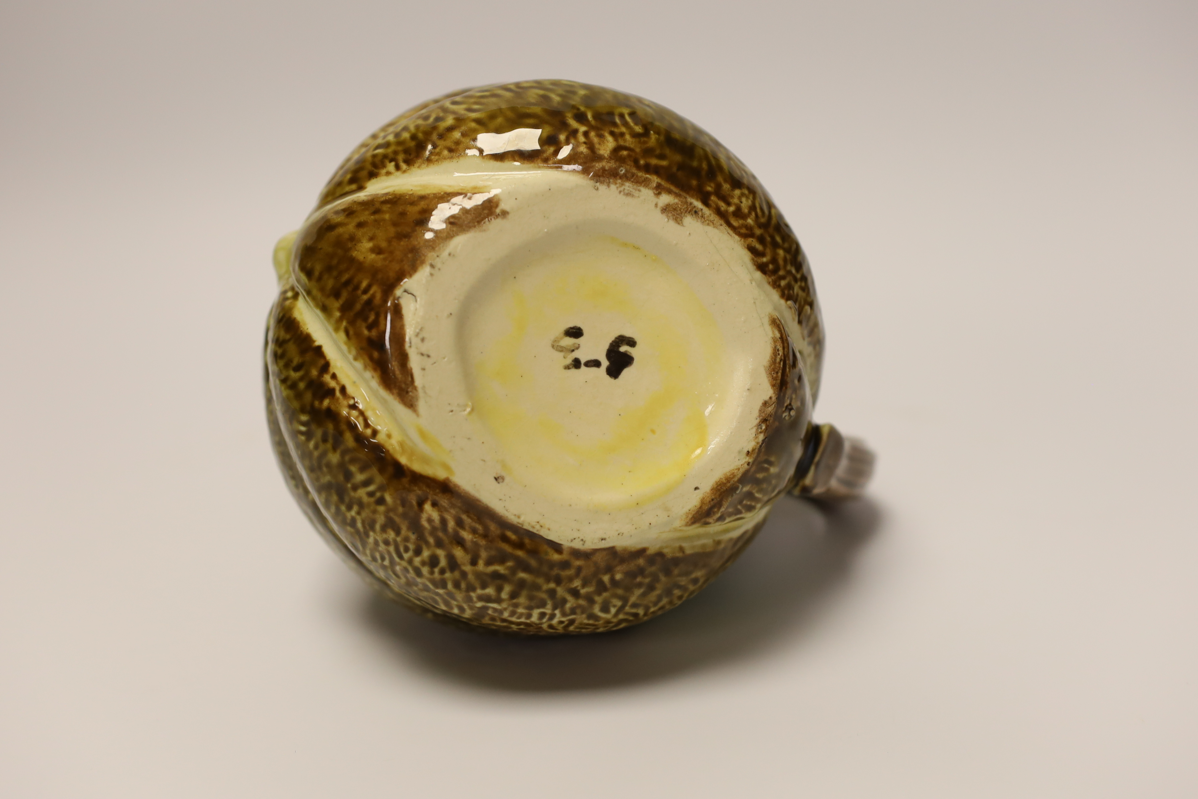 A majolica jug in the form of a frog, sitting on a melon, 17cm high